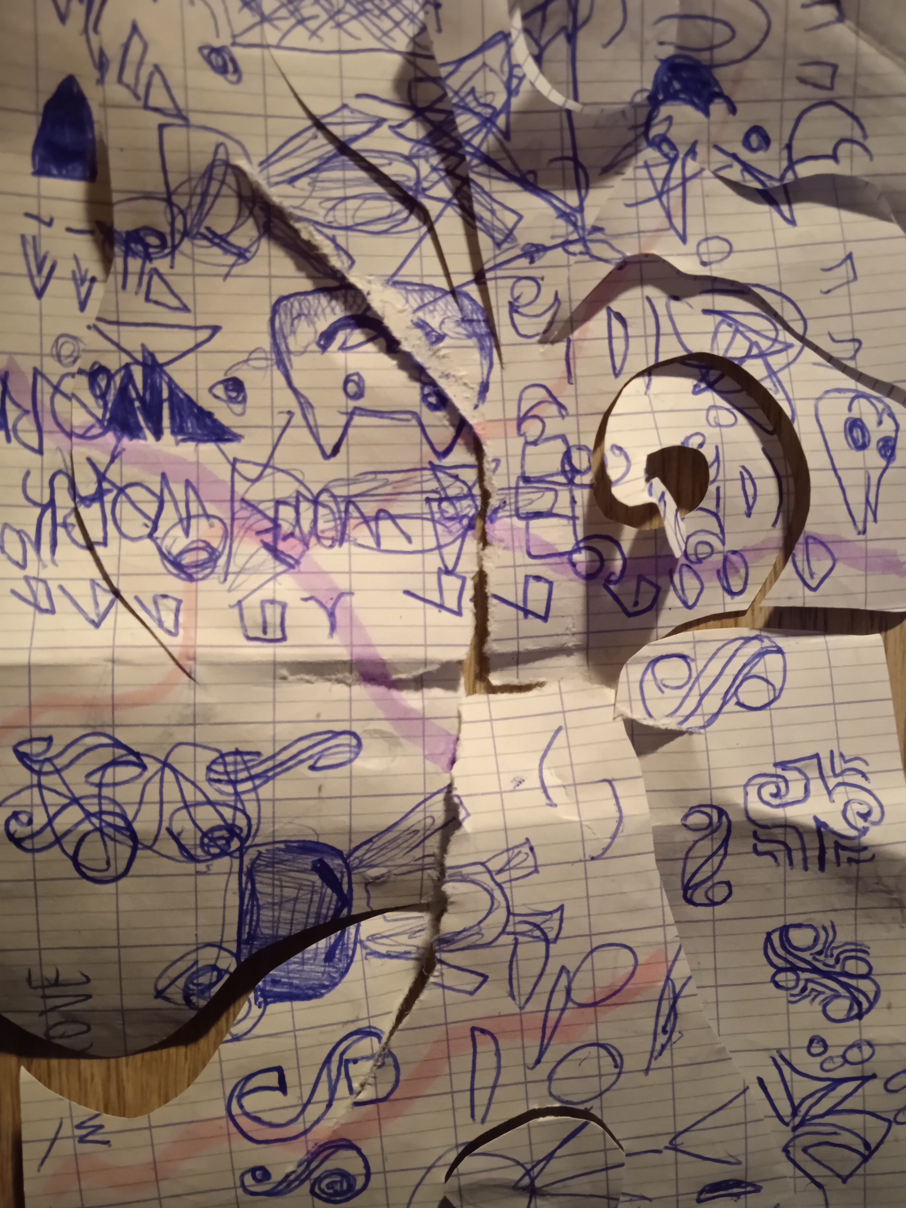a ripped and spiralingly cut piece of paper on which can be seen drawings and glyphs made with a blue pen, and highlighter markings