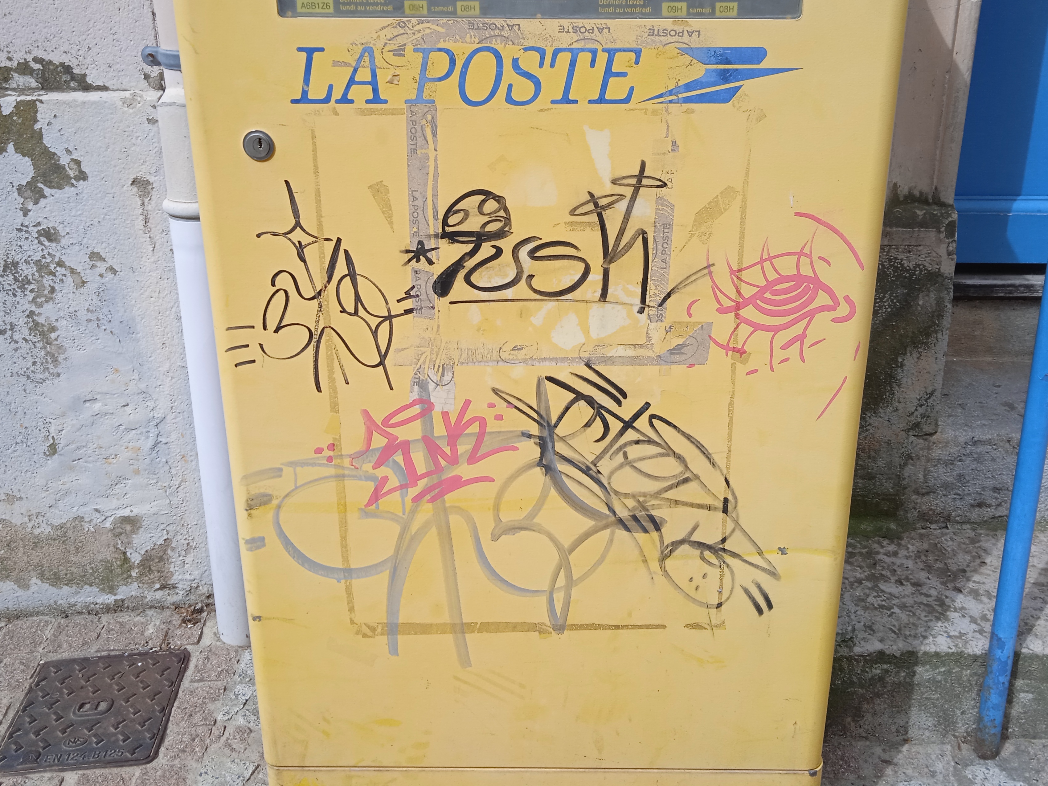 a postbox with graffiti and tape remains on it a postbox with graffiti and tape remains on it