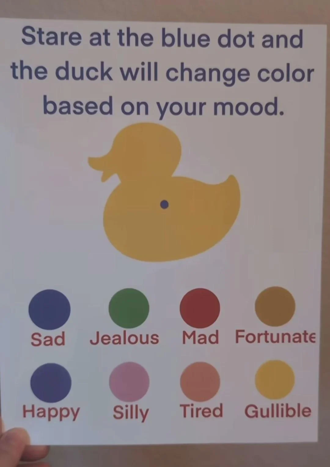 a picture of a sheet of paper on which is written „Stare at the blue dot
and the duck will change color based on your mood.“ and depicted a blue dot on
a yellow duck with differently coloured circles underneath each labelled with a
mood's name, the bottom-right one being of the same colour as the duck and
labelled „Gullible“